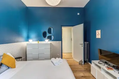 a bedroom with blue walls and a bed with slippers at Domus in Piazza del Popolo in Rome