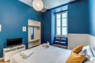 a blue room with a bed and a television at Domus in Piazza del Popolo in Rome