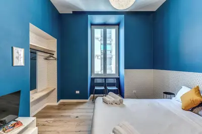 a bedroom with blue walls and a large bed at Domus in Piazza del Popolo in Rome