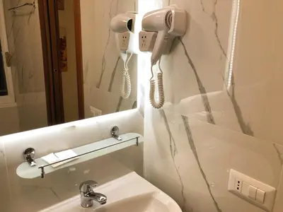 a bathroom with a phone on the wall next to a sink at Hostel Cosmos in Rome