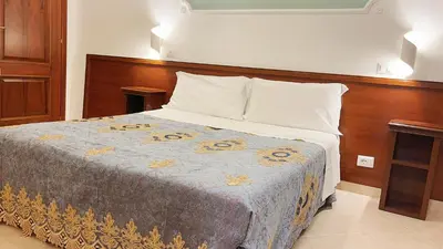 a bedroom with a large bed with a wooden headboard at Hostel Cosmos in Rome