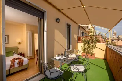 a balcony with a bed and a table and chairs at Hotel Colosseum in Rome