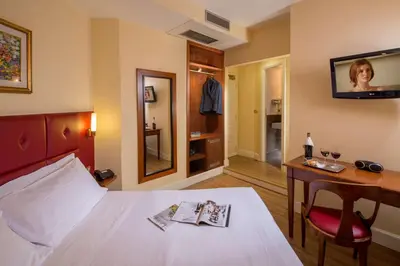 a hotel room with a bed and a desk and a television at Best Western Hotel Astrid in Rome