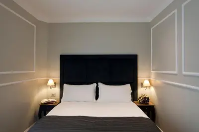 a bedroom with a bed with two night stands and two lamps at Seven Suites in Rome