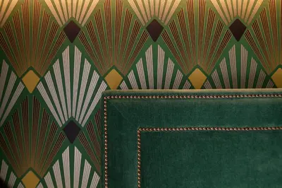 a green couch in front of a patterned wall at Seven Suites in Rome