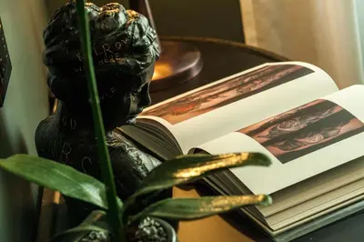 a statue reading a book on a table with a plant at Seven Suites in Rome