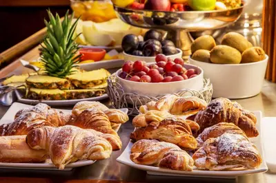 a table topped with plates of pastries and fruit at La Residenza in Rome