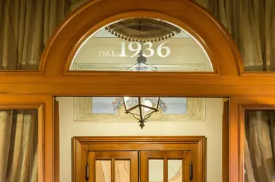 a door with a sign above it with a clock above it at La Residenza in Rome