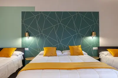 a bedroom with two beds and a green wall at New Morpheus Rooms in Rome