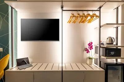 a room with a tv and a desk with a laptop at New Morpheus Rooms in Rome