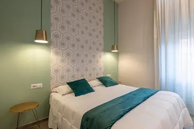 a bedroom with a large white bed with two pillows at New Morpheus Rooms in Rome