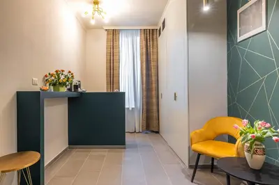 a living room with a table and a yellow chair at New Morpheus Rooms in Rome