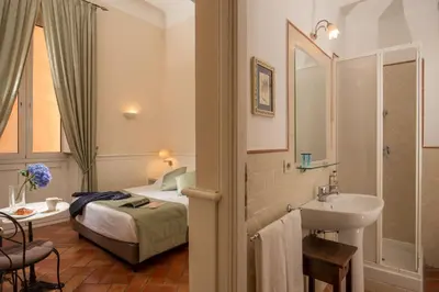 a bathroom with a bed and a sink in a room at Aenea Inn in Rome