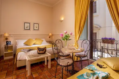 a bedroom with a bed and a table and a balcony at Aenea Inn in Rome