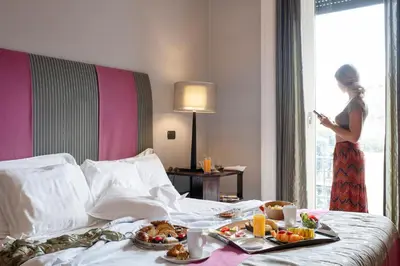 a woman in a hotel room with food on a bed at Alpi Hotel in Rome