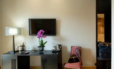 a room with a table with a vase of flowers on it at Alpi Hotel in Rome