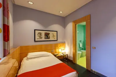 a small bedroom with a bed and a bathroom at Albani Hotel Roma in Rome
