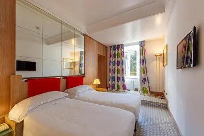 a hotel room with two beds and a mirror at Albani Hotel Roma in Rome