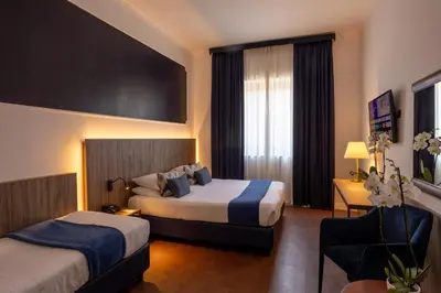 a hotel room with two beds and a couch at Grand Hotel Tiberio in Rome