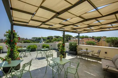 a patio with tables and chairs on a roof at Hotel Alessandrino in Rome