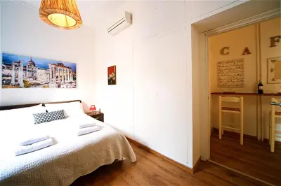 a white bedroom with a bed and a window at Vetrina Holidays Apartment Navona in Rome