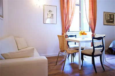 a living room with a table and chairs and a couch at Vetrina Holidays Apartment Navona in Rome