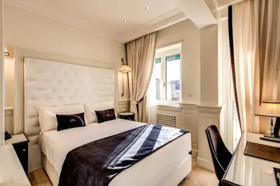 a bedroom with a large white bed and a window at Hotel Domus Mea in Rome