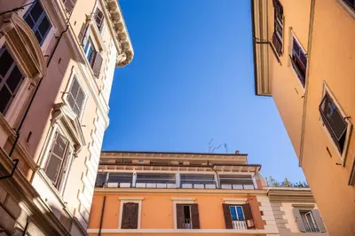 an orange building in the middle of two buildings at Hotel Domus Mea in Rome