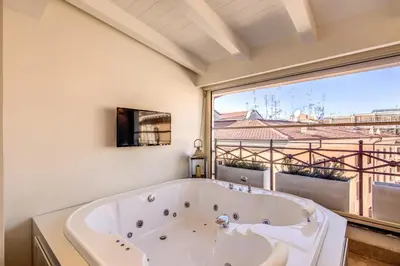a bath tub in a bathroom with a large window at Hotel Domus Mea in Rome