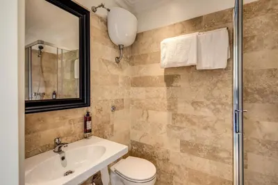 a bathroom with a sink and a toilet and a mirror at Hotel Domus Mea in Rome
