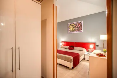 a bedroom with a bed with a red head board at Magnifico Rome in Rome