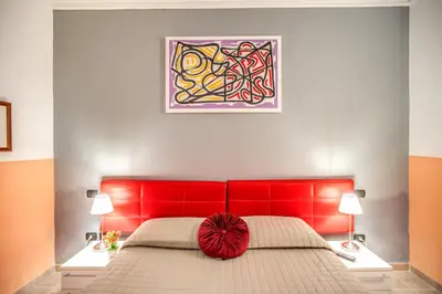 a bedroom with a red bed with a red headboard at Magnifico Rome in Rome