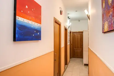 a hallway with paintings on the walls and a door at Magnifico Rome in Rome