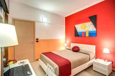 a bedroom with a bed and a desk with a laptop at Magnifico Rome in Rome