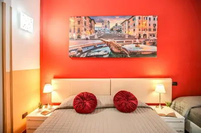 a bedroom with red walls and a bed with red pillows at Magnifico Rome in Rome