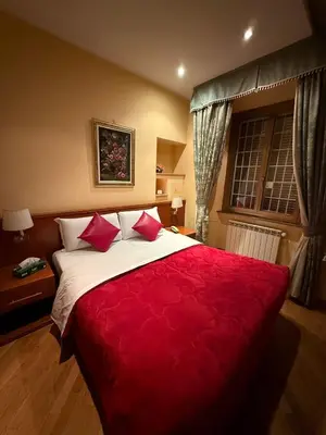 a bedroom with a large bed with red sheets at Hotel Fenicia in Rome