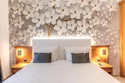 a bedroom with a bed with white flowers on the wall at Roma dei Papi B&B in Rome