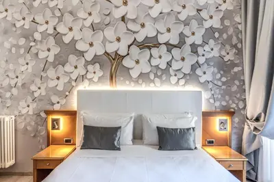 a bedroom with a bed with white flowers on the wall at Roma dei Papi B&B in Rome