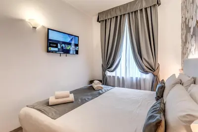 a bedroom with a large bed with a flat screen tv at Roma dei Papi B&B in Rome