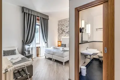 a bedroom with a bed and a sink and a mirror at Roma dei Papi B&B in Rome