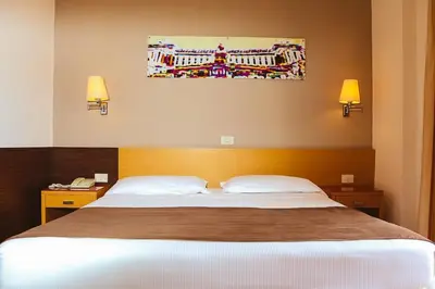 a bedroom with a large bed with two pillows at Hotel Sisto V in Rome