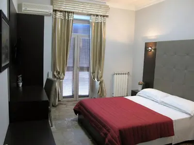 a bedroom with a bed and a window with curtains at Hotel d'Este in Rome