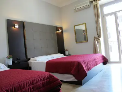 a hotel room with two beds with red sheets at Hotel d'Este in Rome