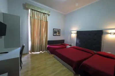 a bedroom with a red bed and a couch at Hotel d'Este in Rome