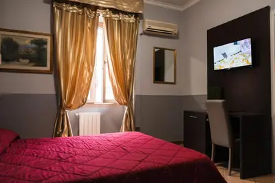 a bedroom with a red bed and a window at Hotel d'Este in Rome