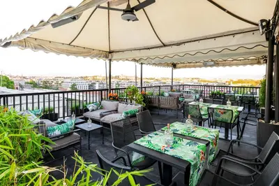 a patio with tables and chairs and an umbrella at Trilussa Palace Hotel Congress & Spa in Rome