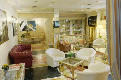 a waiting room with chairs and a couch and tables at Trilussa Palace Hotel Congress & Spa in Rome
