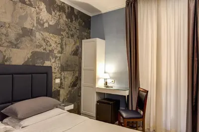 a bedroom with a bed and a desk and a chair at Residenza Belli Inn in Rome