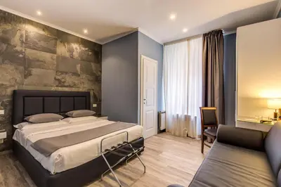 a bedroom with a large bed and a couch at Residenza Belli Inn in Rome