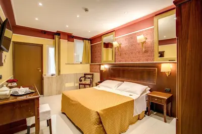 a bedroom with a bed and a table and a desk at Hotel Aurelius in Rome